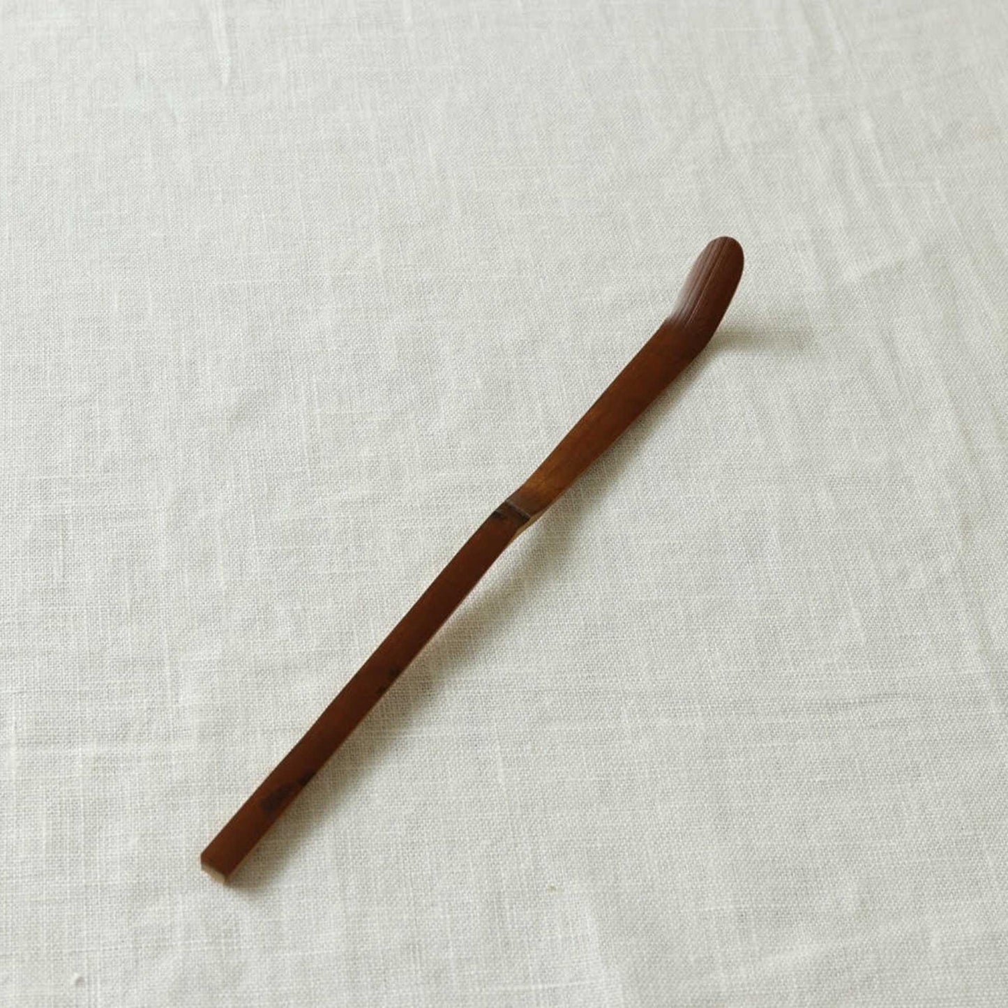 Close-up of the elegant handcrafted bamboo curve on Kohchosai Kosuga tea scoop