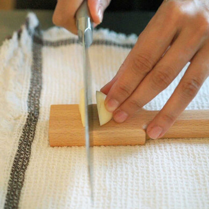 Scraping fresh ginger paste from a copper grater using ASAKURA bamboo kitchen brush