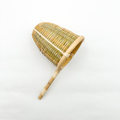 Handcrafted medium bamboo tea infuser resting on a standard ceramic tea cup